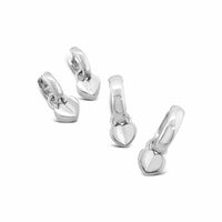 Set of silver heart-shaped earrings on a white background